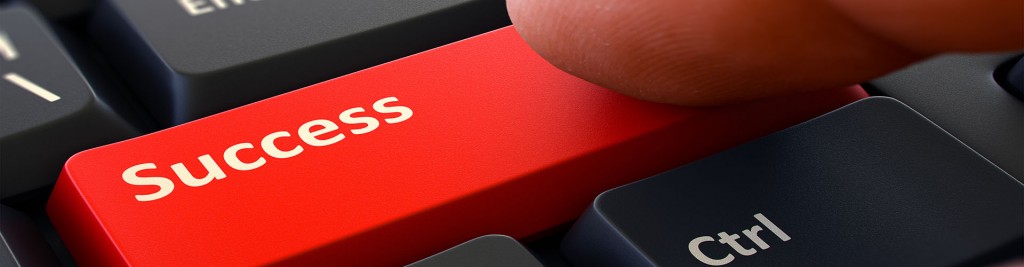 Success Red Button - Finger Pushing Button of Black Computer Keyboard. Blurred Background. Closeup View.