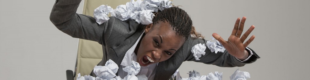African business woman is tired of work . Sitting in front of crumpled paper pile . Unhappy with cv